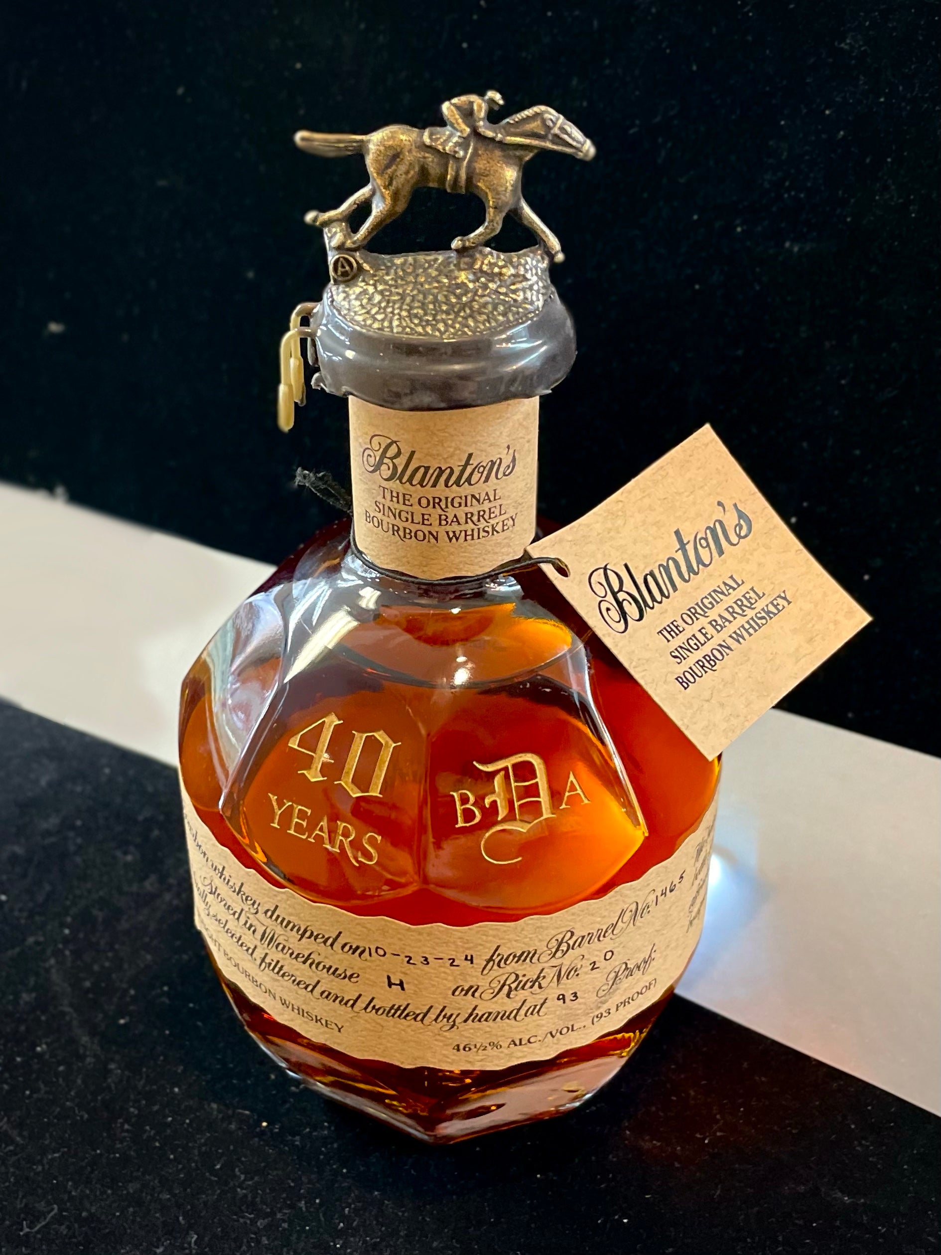 Personalized bottle of Blanton's bourbon whiskey with decorative cap on a dark background